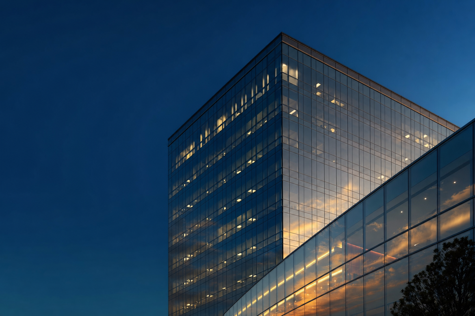 Modern glass office tower at dusk